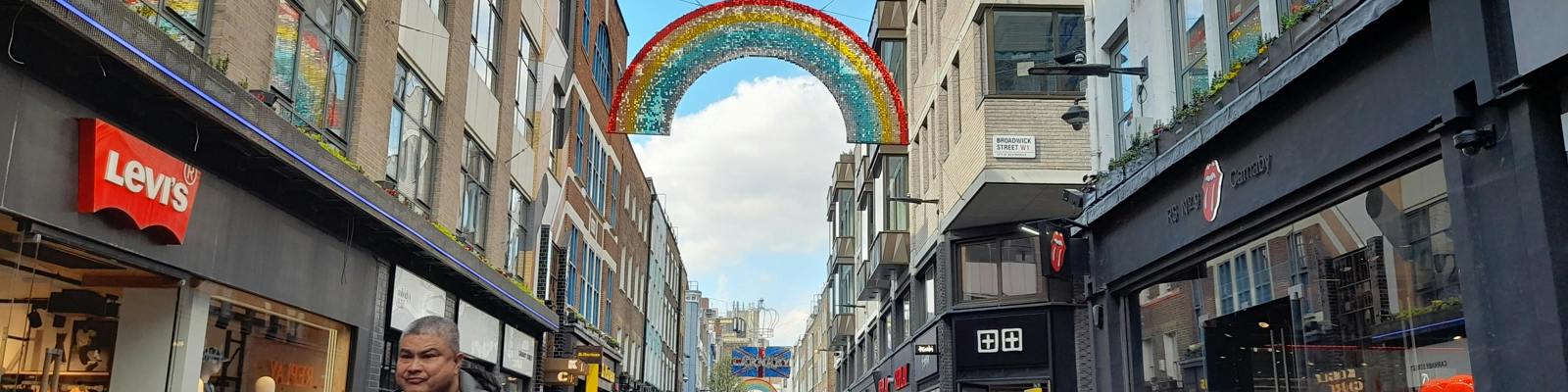 A shopping street in a city, with people walking between shops