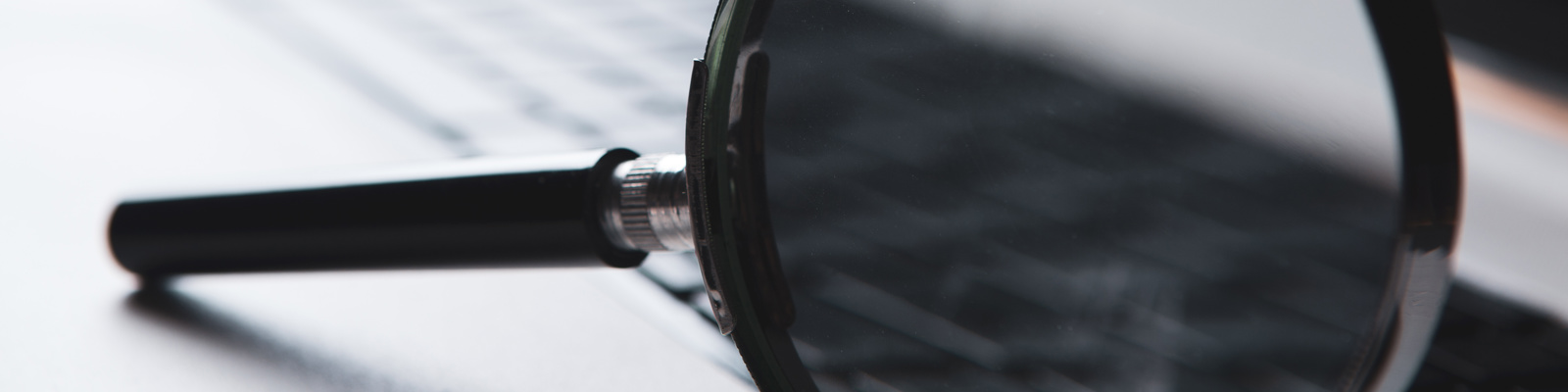 Photo of a magnifier glass sitting on a laptop